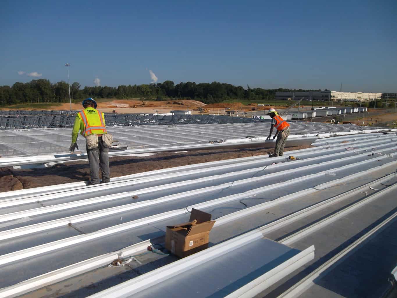 Two men in hard hats working on construction for a project